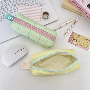 Detailed view of quilted bubble puffer pencil cases with contrast zippers in pastel colors