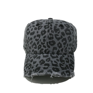 Close-up of vintage leopard print baseball cap featuring distressed torn brim details