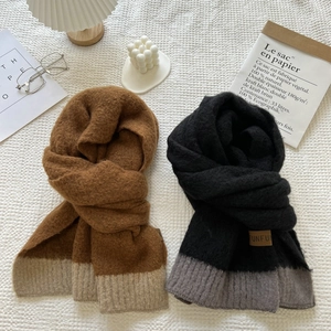 Flat lay of soft knit scarves in brown beige and black grey colorblock patterns