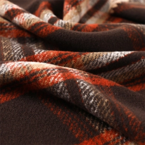 Macro shot of soft plaid cashmere scarf fabric in brown, orange and cream textures