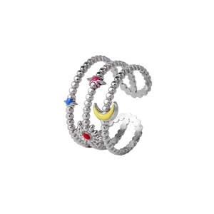 Vue détaillée d'une bague ouverte argentée avec des motifs émaillés soleil, lune et étoile