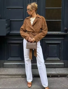 Detail of a brown suede jacket with a lapel collar and waist tie for casual street wear