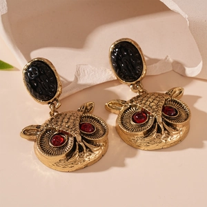 Vintage owl drop earrings in antique gold finish with red gemstone eyes and black accents