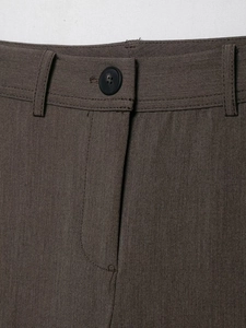 Détail du pantalon marron foncé avec coutures blanches et fermeture à bouton noir