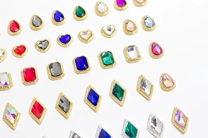 Vista macro detallada de dijes de piedras preciosas con bordes dorados para el arte de uñas