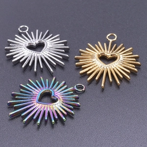 Detailed view of heart sunburst charms in silver, gold and rainbow stainless steel