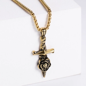 Vintage punk style rose and dagger pendant necklace on a gold square bead chain