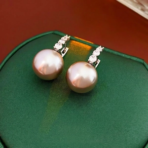Close-up of vintage pink pearl earrings with shimmering zircon drop detailing