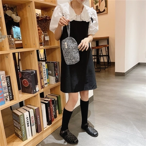 Gros plan sur la trousse à maquillage à motif zèbre tenue dans une bibliothèque