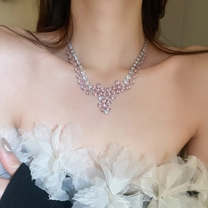 Dettaglio ravvicinato di una collana a fiori con zirconi indossata sul collo
