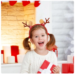 Smiling girl wearing Christmas reindeer antler headband with festive holiday accessories