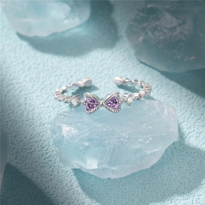 Detail of adjustable silver ring featuring purple heart stones and bead texture band