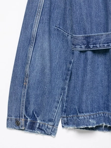 Close-up of long denim jacket with metal buttons, waist belt and frayed hem edge