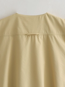 Gros plan détaillé du gilet jaune clair avec boucle de suspension et coutures au dos