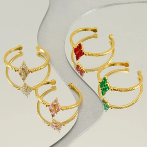 Detail of adjustable gold-tone rings with marquise-cut colorful zircons on a mirror