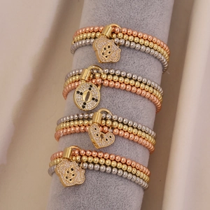 Three-color beaded elastic bracelets with heart and lock pendants on velvet display