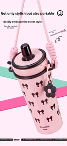 Pink insulated cup with bow pattern featuring an adjustable wide woven shoulder strap