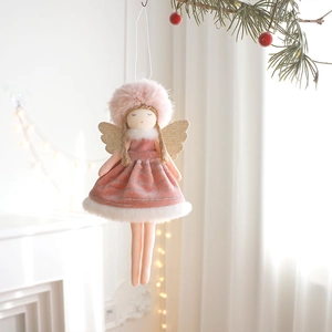 Pink plush angel girl Christmas ornament with gold wings hanging on a pine tree branch