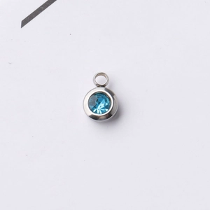 Close-up of a 6.5mm stainless steel round pendant with a vibrant blue birthstone inlay