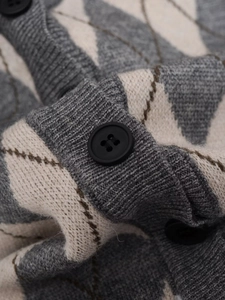 Detailed view of argyle knit cardigan featuring grey texture and black resin buttons