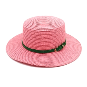 Détail du chapeau de paille rose avec ceinture en similicuir vert foncé et boucle