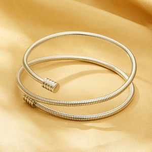 Close-up of silver multi-layer spiral cable spring bracelet on golden silk fabric