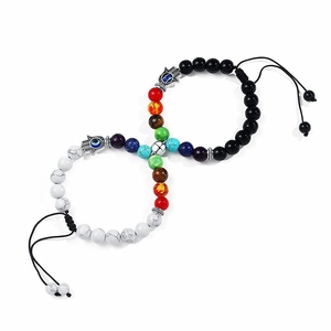 Detail of magnetic couple bracelets with white turquoise beads and Hamsa hand charms