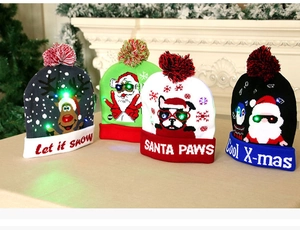 Close-up of knit Christmas beanies with festive patterns and glowing LED lights
