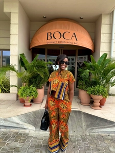 Detail of African Ankara print two-piece set with vibrant orange patterns and wide-leg pants