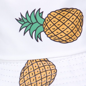 Detailed close-up of stitching and yellow pineapple print on a white canvas bucket hat