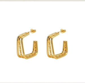 Close-up of golden multi-layer square geometric stud earrings with a polished finish