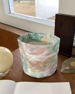 Detailed view of quilted floral fabric organizer on a wooden desk near a sunny window