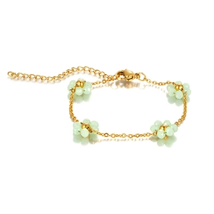 Detailed shot of handmade bohemian beaded flower bracelet with mint green beads and gold chain