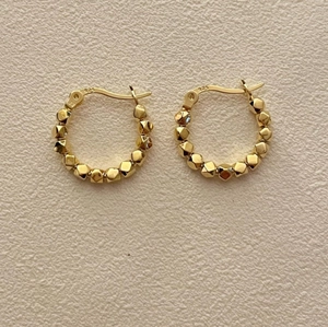925 sterling silver gold hoop earrings with faceted bead design on ivory texture