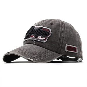 Close-up of distressed brim and 3D vintage embroidery on a washed grey baseball cap