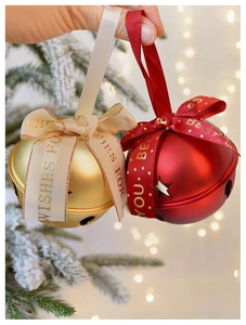 Close-up of matte gold and red Christmas bells with Best Wishes ribbon on tree
