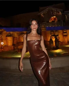 Gros plan sur le tissu à paillettes marron d'une robe de soirée moulante et brillante