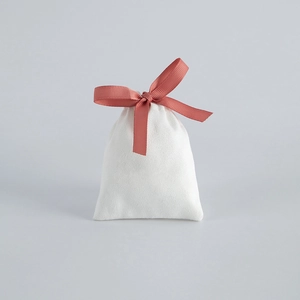 Elegant white velvet drawstring jewelry pouch with coral pink ribbon bow decoration