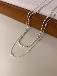 Dettaglio macro della collana doppia in argento con perle ovali e catena a sfere fini