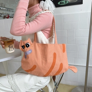 Detail of cute orange cat tote bag featuring 3D tail and funny embroidered expression