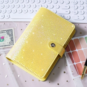 Macro shot of yellow glitter PU leather A6 binder with metallic snap closure and stars