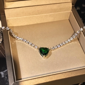 Macro-opname van een hartvormige groene edelsteenketting in een luxe juwelendoos