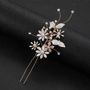 Detailed macro view of wedding hair clip with white flowers, pearls and golden wire