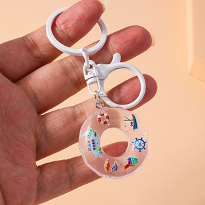 Close-up of white lifebuoy keychain with resin donut charm for water safety education