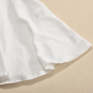Detailed view of white pleated mini dress fabric with hollow-out knit texture