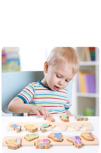Toddler playing with wooden dinosaur and construction vehicle shape matching puzzle boards