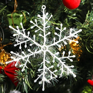 Sparkling white 11cm plastic snowflake ornament hanging on a decorated Christmas tree