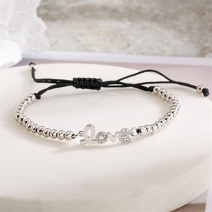 Détail d'un bracelet en cordon noir réglable avec breloque LOVE argentée et cristaux