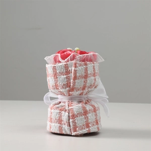 Close-up of pink soap flower bouquet with white lace and pink checkered fabric wrap