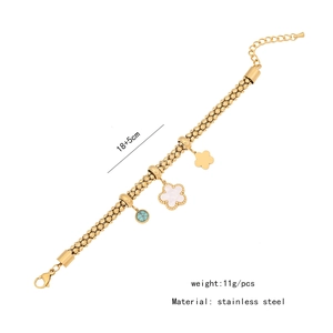 Detail of gold stainless steel bracelet with floral motifs and green turquoise inlay